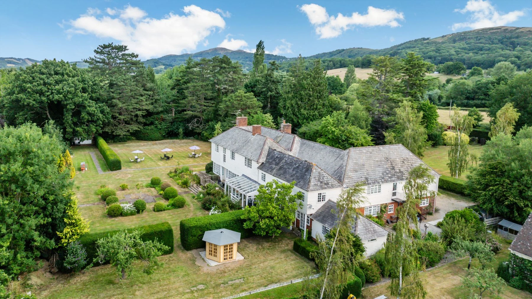 Aerial view of the gardens with a summerhouse, hedges and parasols