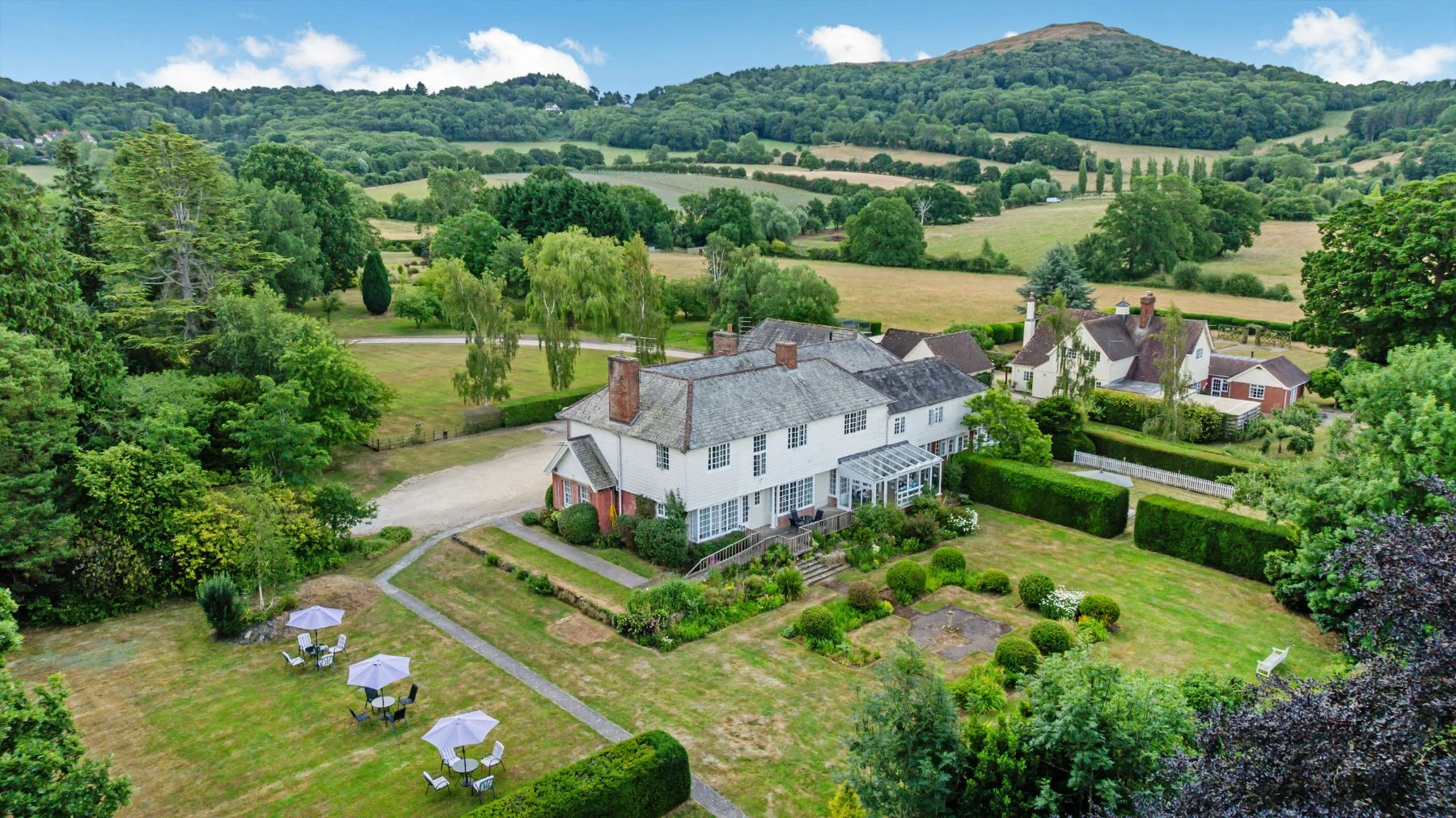 Aerial view of Evendine House and its gardens with the Malvern Hills behind